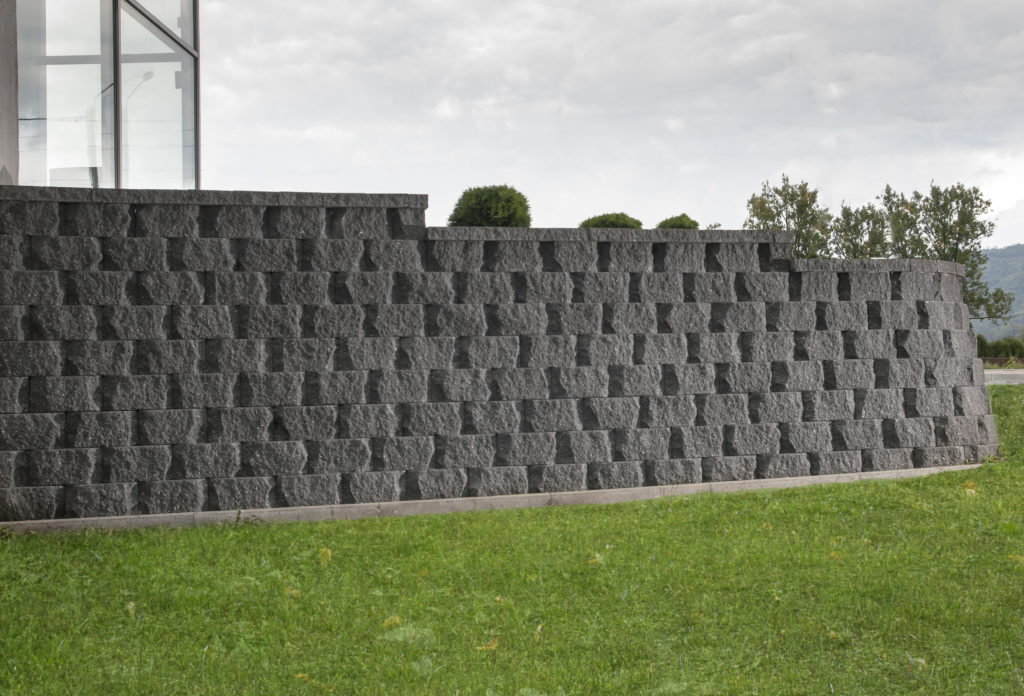 Mur oporowy z pustaków łupanych łukowo prefabrykowanych z gruntu zbrojonego CJ BLOK PBO-25-Ł grafit